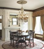 Dining room with white moulding and panels along the featured wall with dark brown moulding along the top of the wall