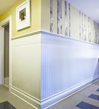 Yellow walls with wainscot half way up the wall with white baseboards