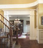 Beige walls with white casing around them with white panels and an oak staircase